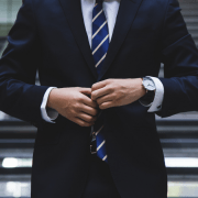 Man in a suit adjusting jacket in front of stairs